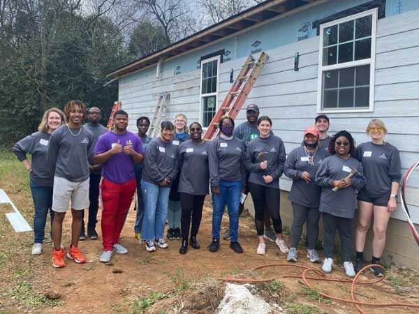 Leadership program students standing outside of the home they helped build with Macon Habitat for Humanity.